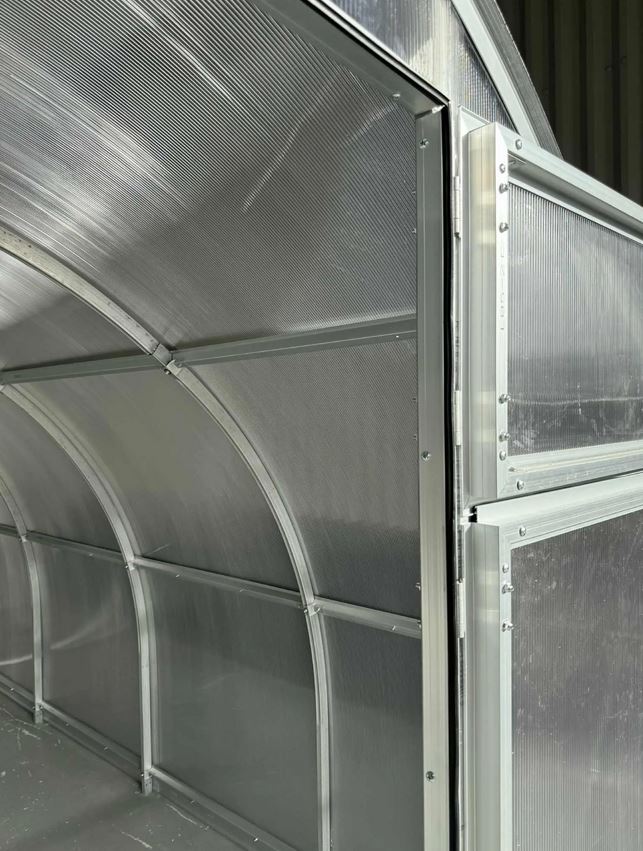 Szklarnia PREMIUM Sigma EVO 3×8 m, poliwęglan 6 mm Drzwi szklarni PREMIUM Sigma EVO z poliwęglanu 6 mm oraz widoczna stalowa konstrukcja wnętrza