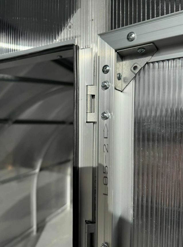Szklarnia PREMIUM Sigma EVO 3×8 m, poliwęglan 6 mm Detal zawiasu i skręcanej ramy drzwi szklarni PREMIUM Sigma EVO z poliwęglanu